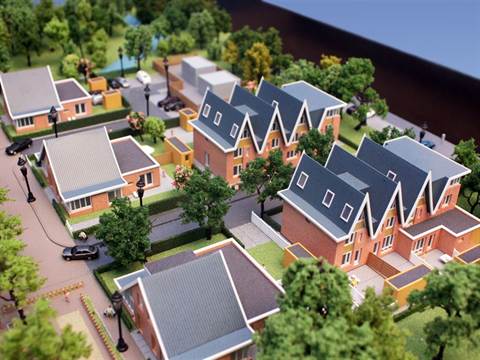 Maquette van rijwoningen met puntdaken en tuinen in een woonwijk