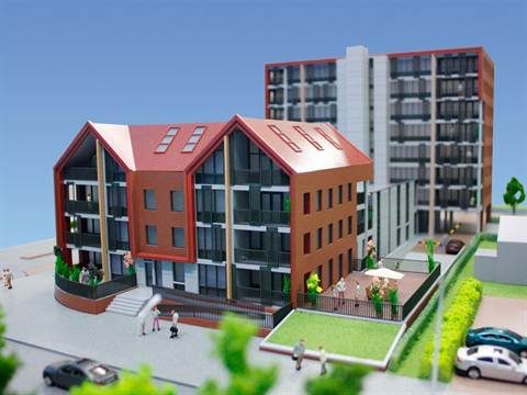 Maquette van een appartementencomplex met rode puntdaken naast een hogere flat